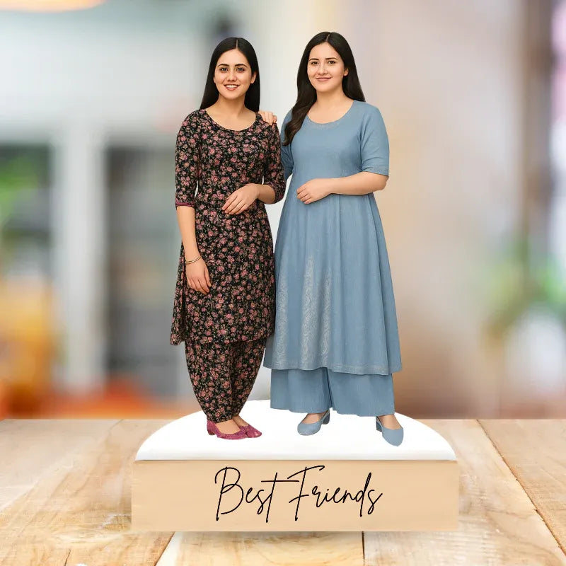 Two women in floral and blue outfits with 'Best Friends' text on a wooden surface.