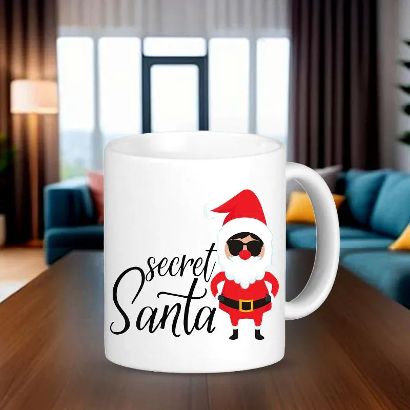 White mug with a cartoon Santa Claus design and 'secret Santa' text on a wooden table.
