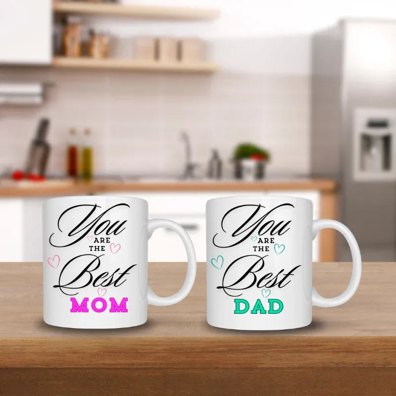 Two white mugs with 'You are the Best Mom' and 'You are the Best Dad' text in a kitchen setting.