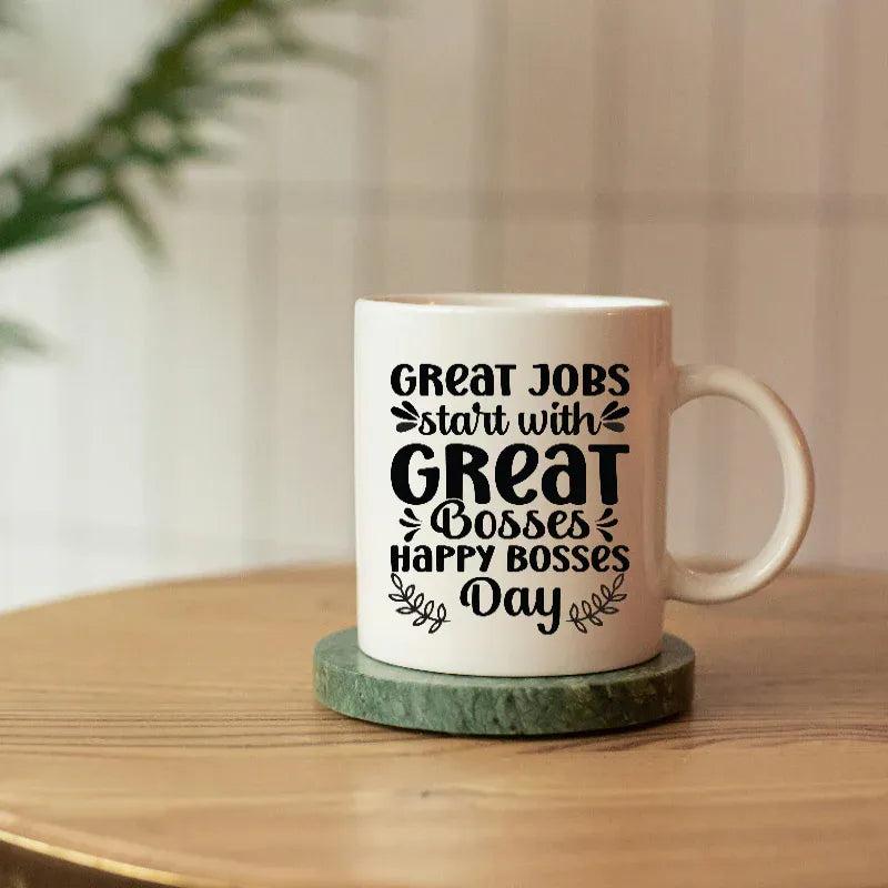 Mug with 'Great jobs start with great bosses. Happy bosses day' text on a wooden surface.
