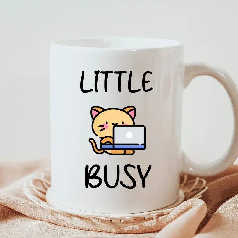 White mug with a cartoon cat and text 'Little Busy' on a light background