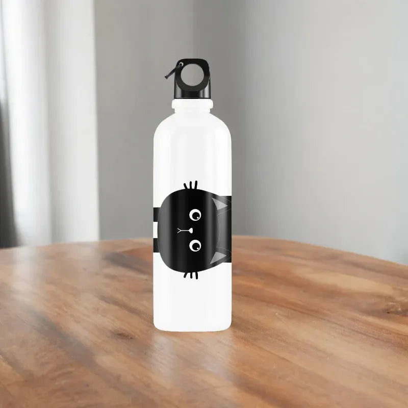 White water bottle with black cat design on a wooden table