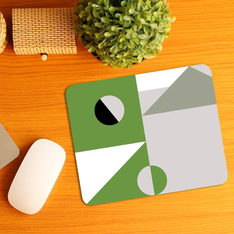 Geometric mouse pad on a wooden desk with a plant and office items.