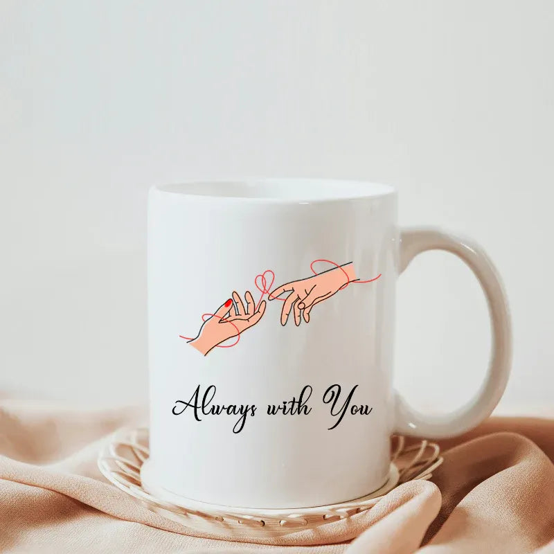 White mug with 'Always with You' text and hand illustration on a light background