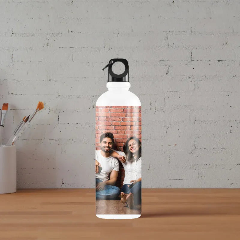 Personalized water bottle with a photo of two people on a brick wall background