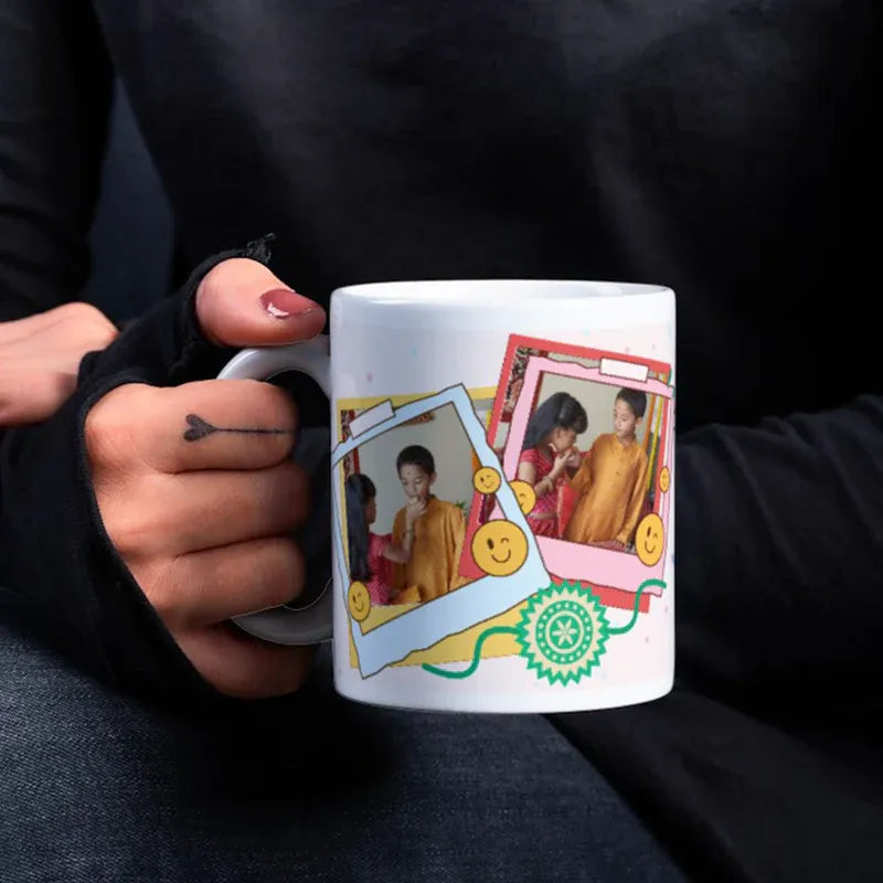 Person holding a mug with colorful design featuring people and decorative elements.