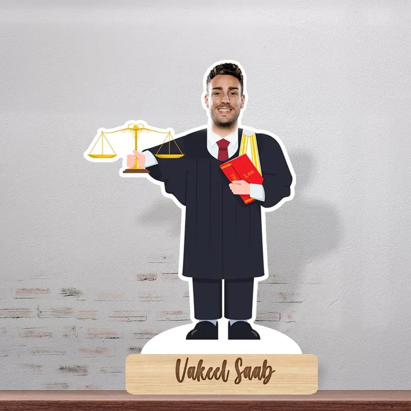 Cardboard cutout of a lawyer holding scales and a book on a stand with 'Vakeel Saab' branding.