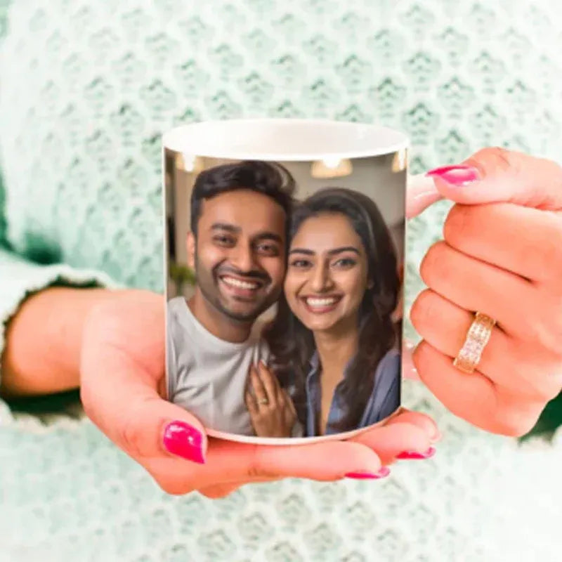 Person holding a mug with a printed photo of a couple on a textured green background