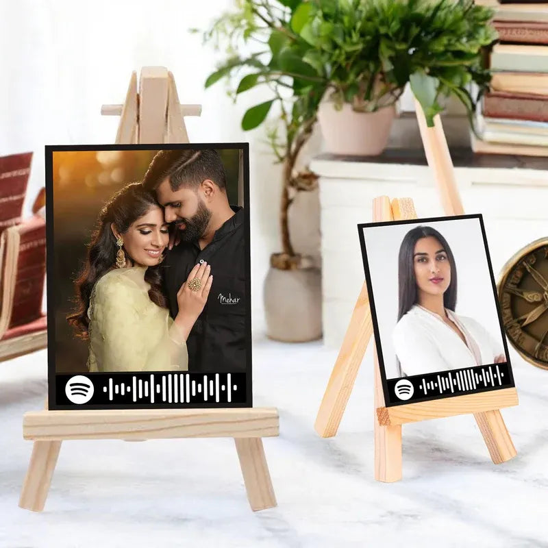 Two portrait frames on easels with a couple and a woman, featuring Spotify logo.