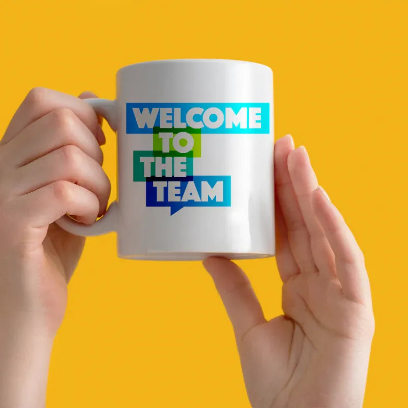 White mug with 'Welcome to the Team' text on a yellow background