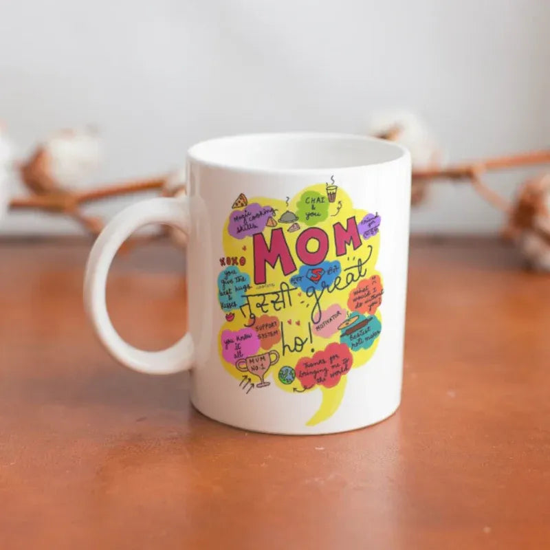 White mug with colorful 'Mom' design on a wooden surface
