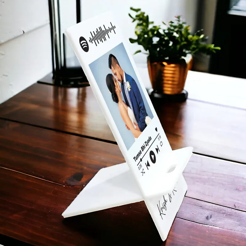 White photo stand with a printed photo on a wooden surface