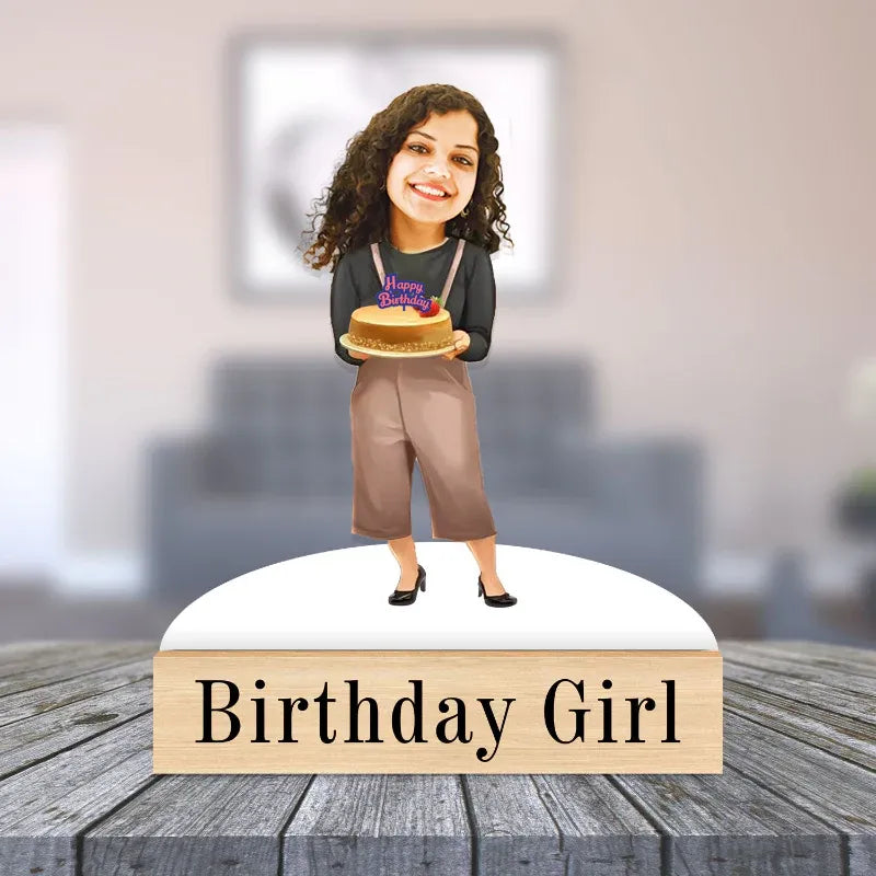Figurine of a girl holding a cake with 'Happy Birthday' text, standing on a platform labeled 'Birthday Girl'.