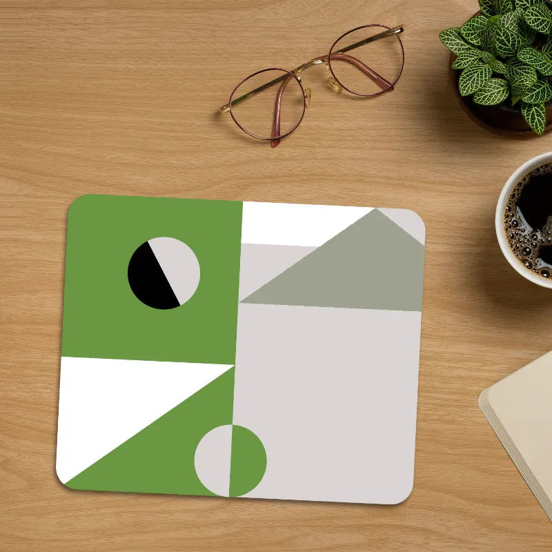 Geometric mouse pad on a wooden desk with glasses and a plant