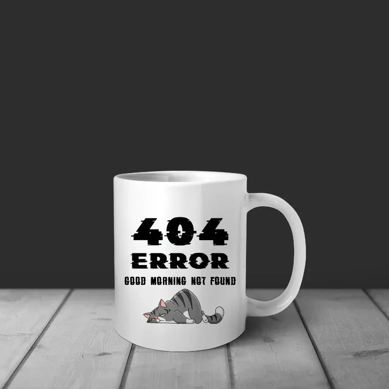 White mug with '404 Error Good Morning Not Found' text and a cat illustration on a wooden surface.