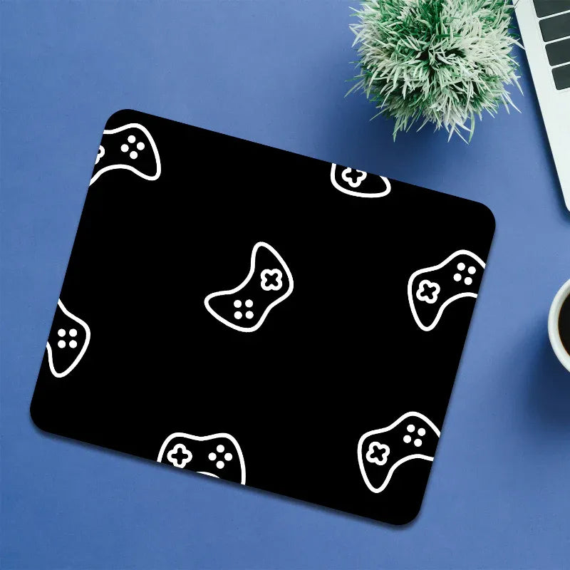 Black mouse pad with white game controller patterns on a blue surface