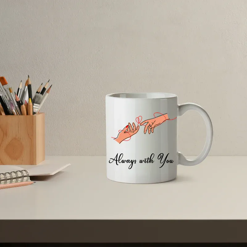 Mug with 'Always with You' design on a desk with stationery items.