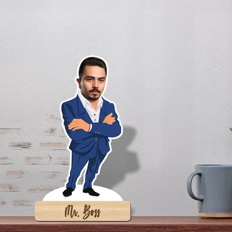 Figurine of a man in a blue suit labeled 'Mr. Boss' on a wooden base with a gray mug in the background.