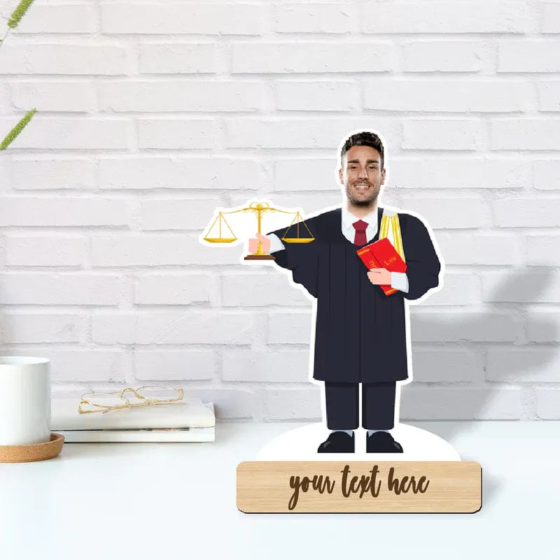 Graduation-themed decorative piece with a man in a gown holding a diploma, on a white surface with a light wood base.