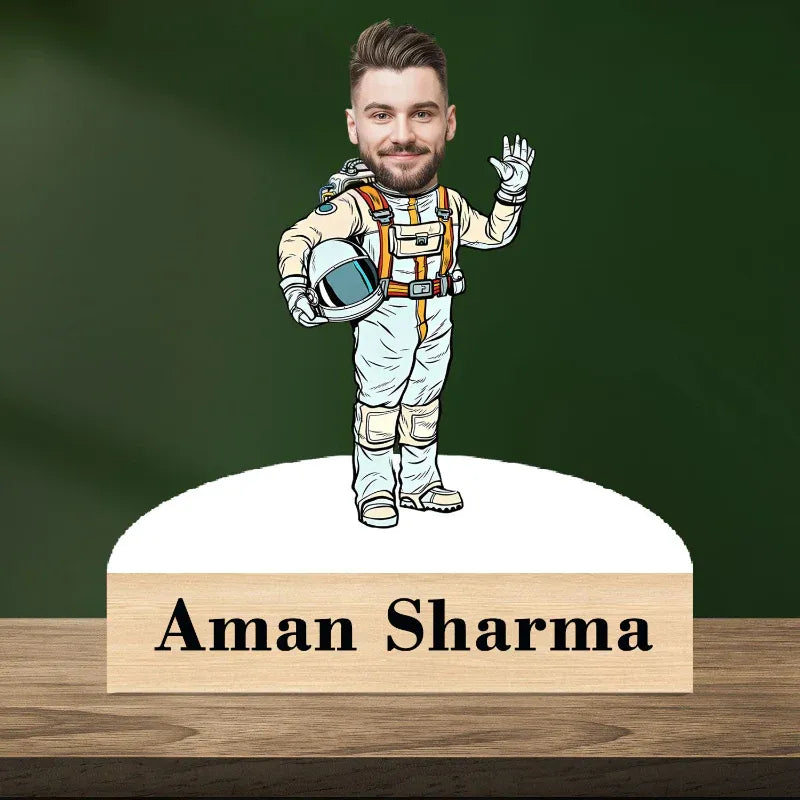 Cartoon astronaut figure with a nameplate on a wooden base against a green background