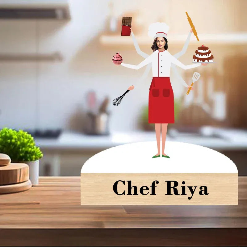 Figurine of a chef with multiple arms holding kitchen utensils on a wooden base labeled 'Chef Riya' in a kitchen setting.