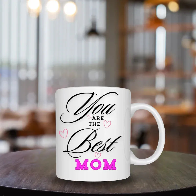 White mug with 'You are the Best Mom' text on a blurred restaurant background