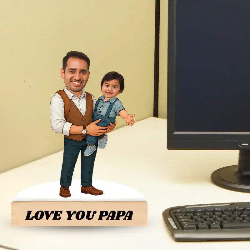 Figurine of a man holding a child with 'Love You Papa' text on a desk.