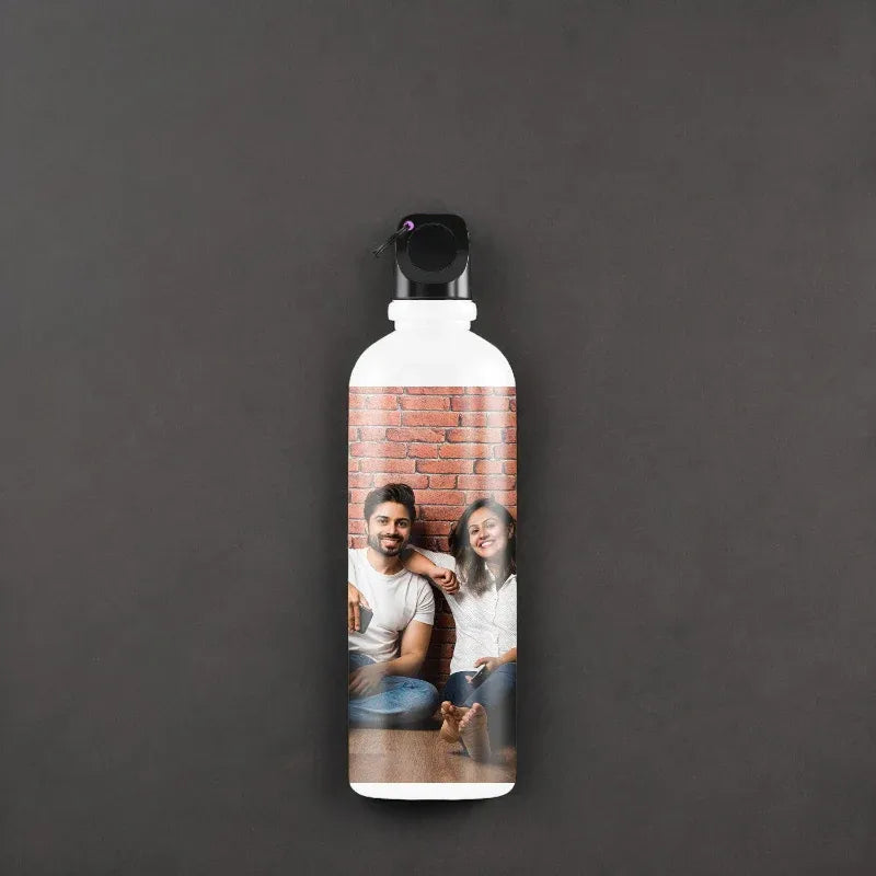 Personalized water bottle with a photo of two people on a brick wall background