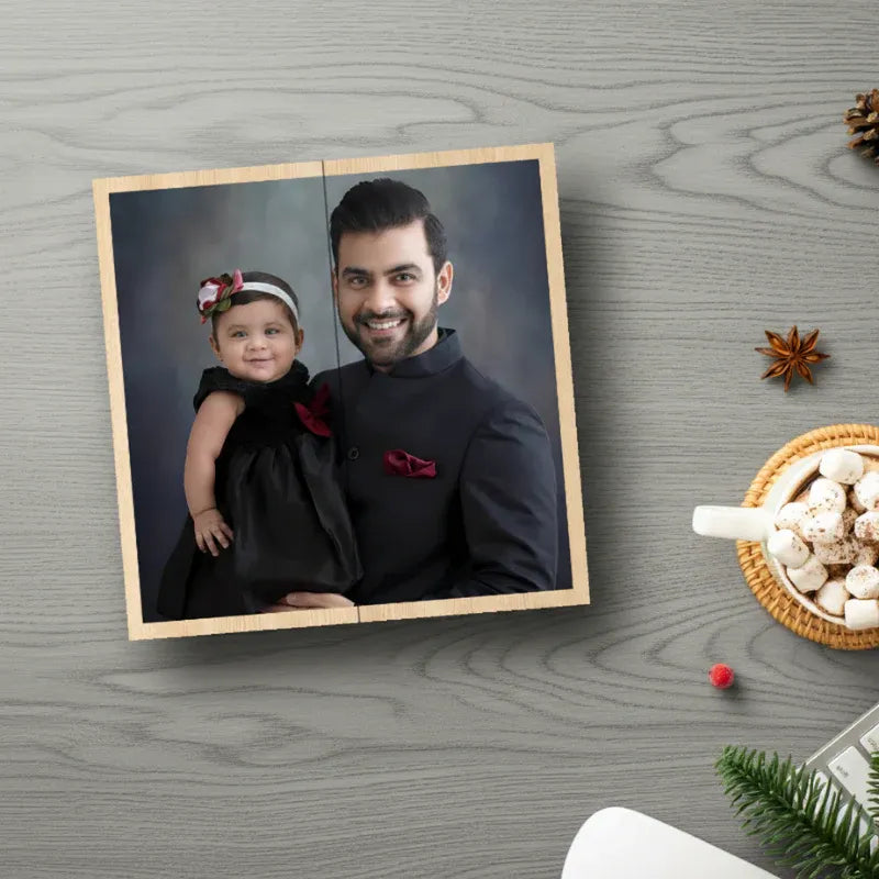Framed photo of a man holding a baby on a wooden surface with decorative items.