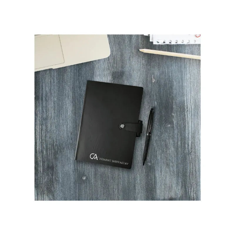 Black notebook with a pen on a textured surface