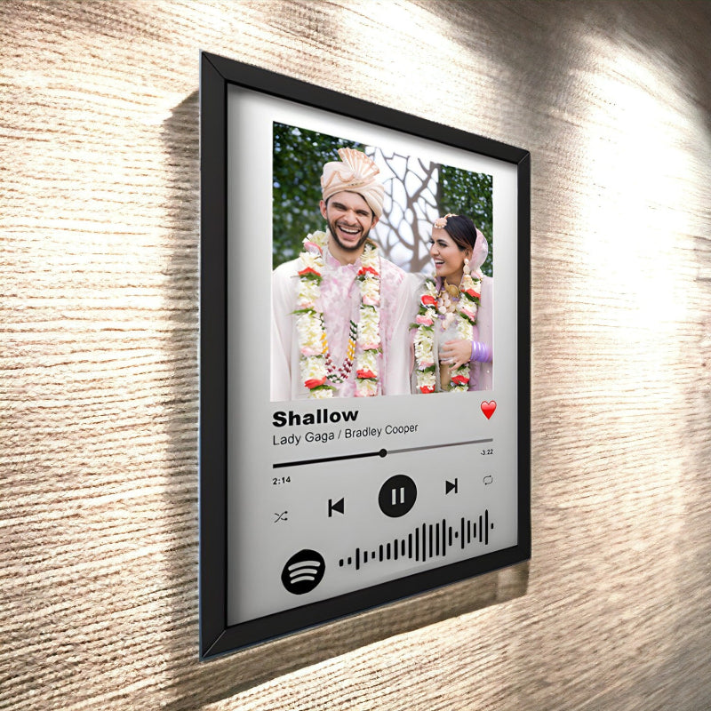Framed artwork of a couple with a music player interface on a textured wall.