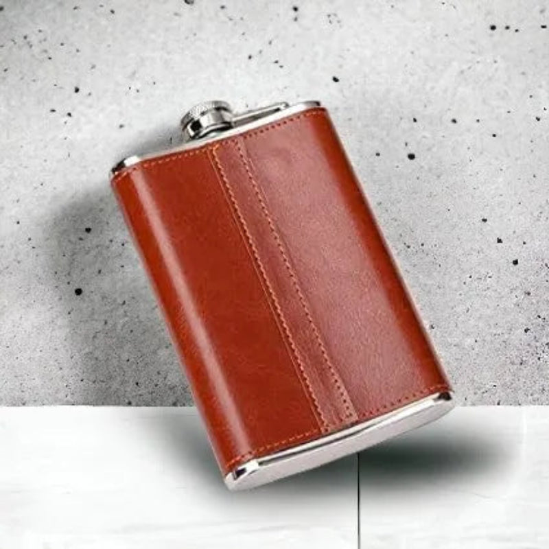 Brown leather flask with silver accents on a gray surface