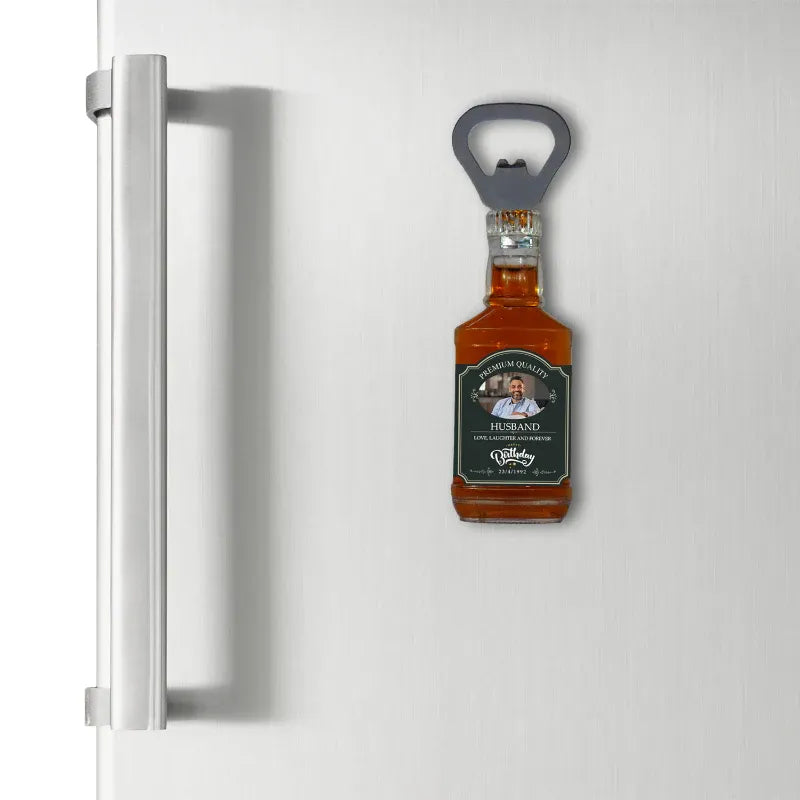 Magnetic bottle opener shaped like a bottle of whiskey on a refrigerator door.