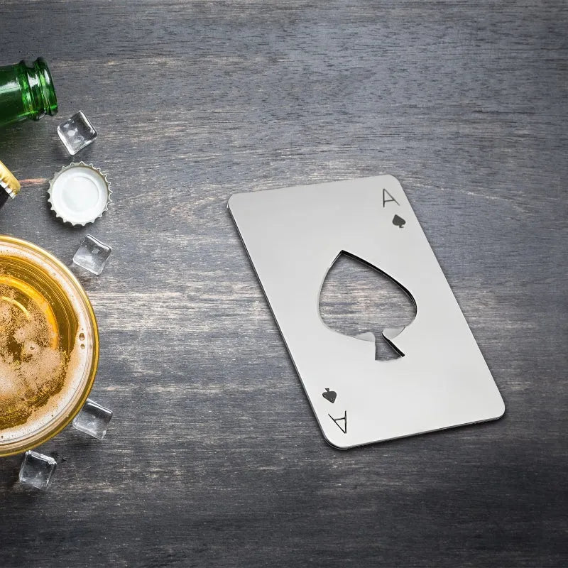 Metallic bottle opener card-shaped bottle opener on a wooden surface with a beer and bottle cap.