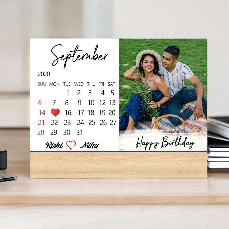 Calendar with a photo of a couple and personalized text on a desk.