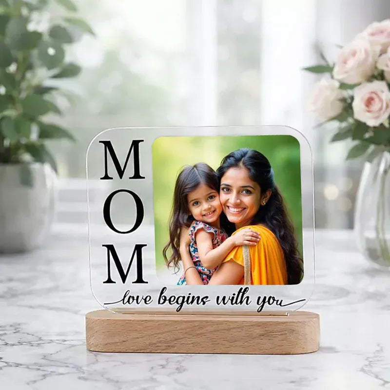 Personalized mother photo frame with 'MOM' and a photo of a woman and child on a marble surface.