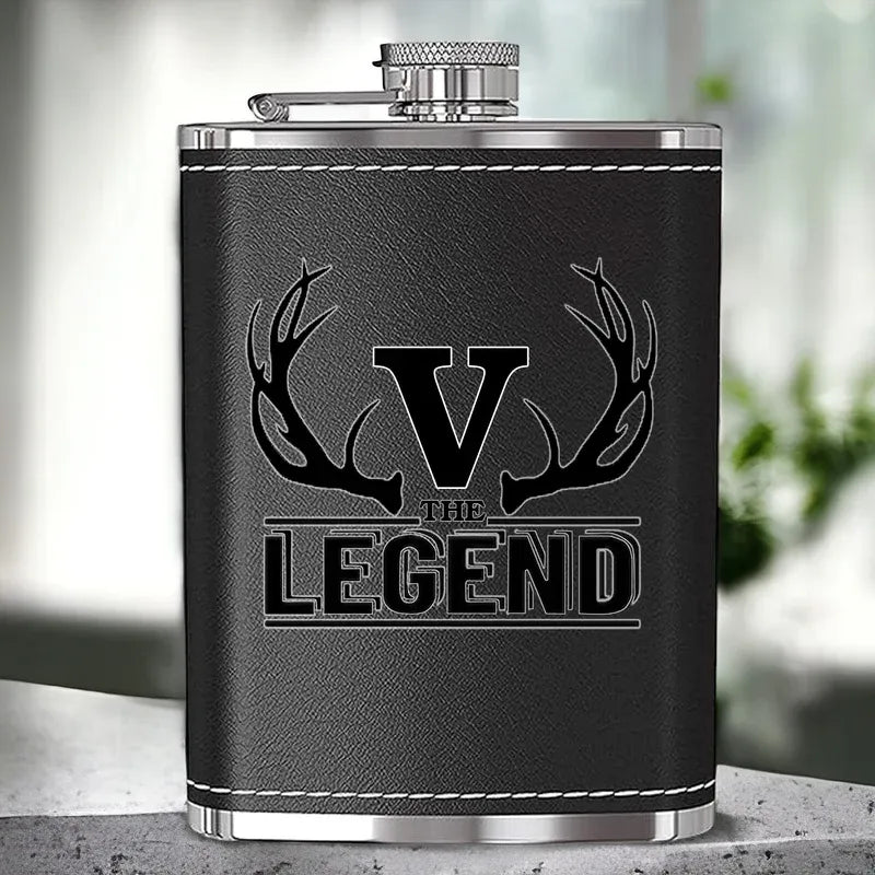 Black leather flask with 'V The Legend' engraving on a blurred background