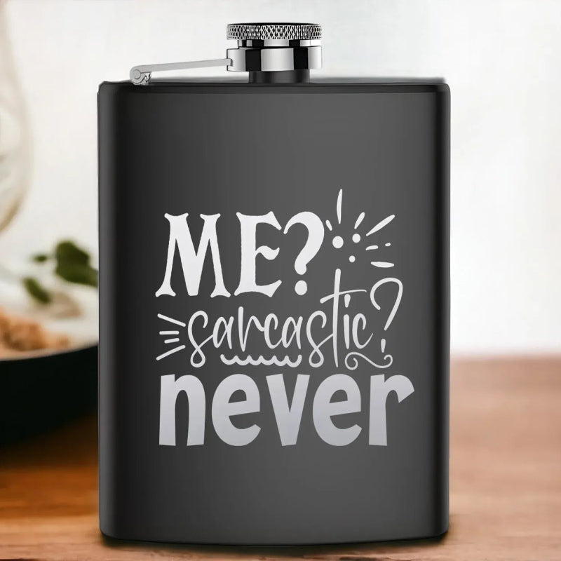 Black flask with white text 'ME? sarcastic? never' on a wooden surface.