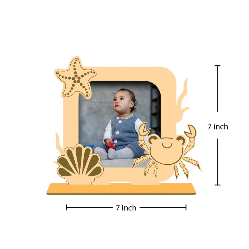 Decorative photo frame with sea-themed designs and a baby photo inside, on a white background.