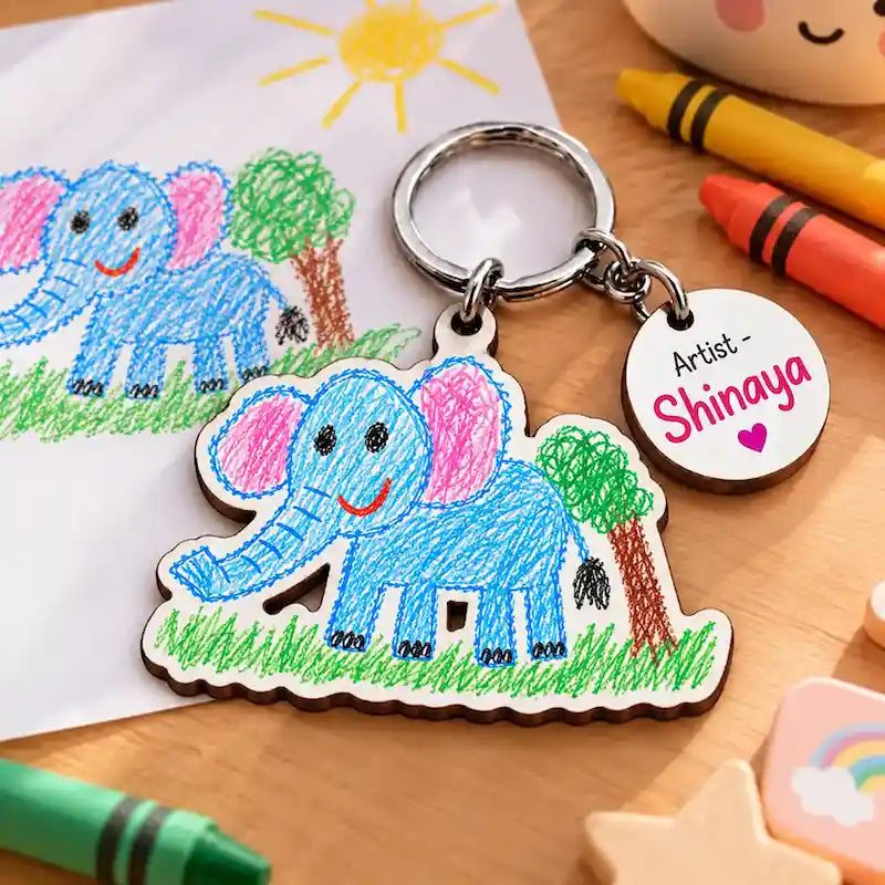Personalized children's drawing keychain with a crayon elephant, sun and tree on laser-cut MDF, with round "Artist – Aarna" name tag