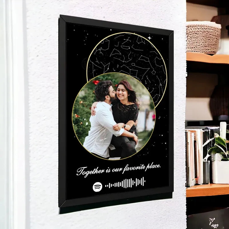 Framed artwork with a couple embracing and a Spotify music code, on a white wall.