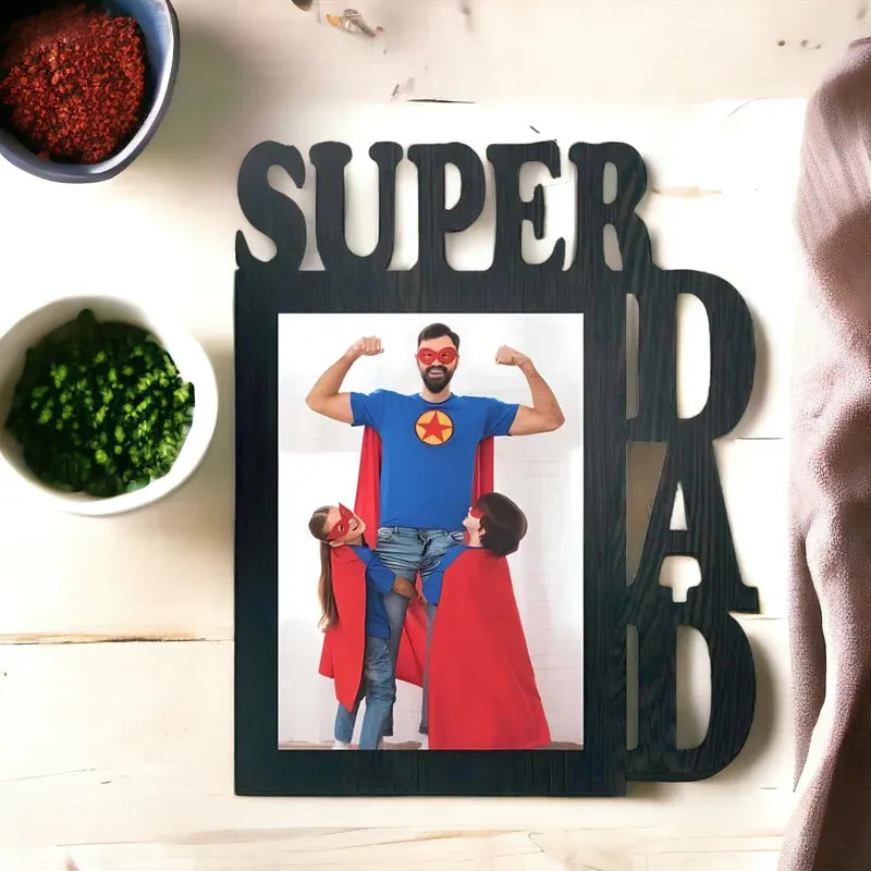 Decorative photo frame with 'SUPER DAD' text and a picture of a man and child in superhero costumes.