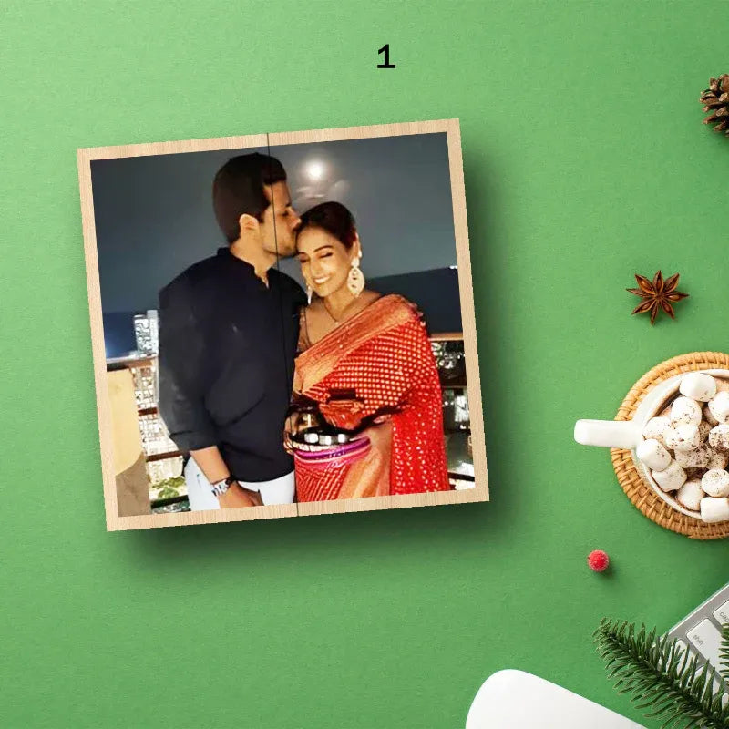 Wooden photo cube with a couple on a green background with festive decorations.