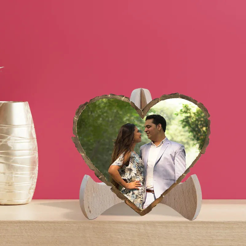 Heart-shaped photo frame with a couple's picture on a pink background