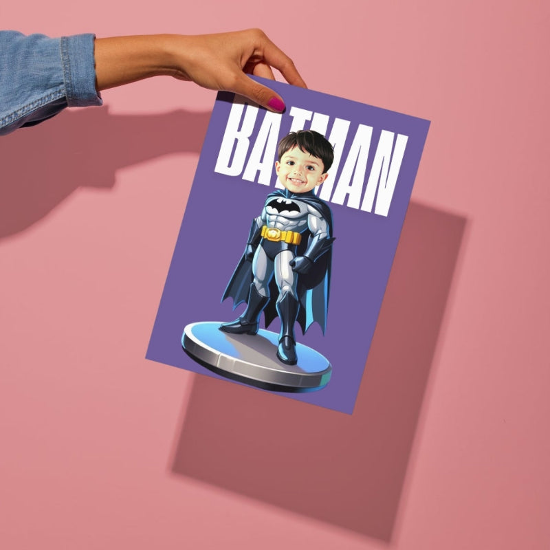 Hand holding a card with a child dressed as Batman on a pink background