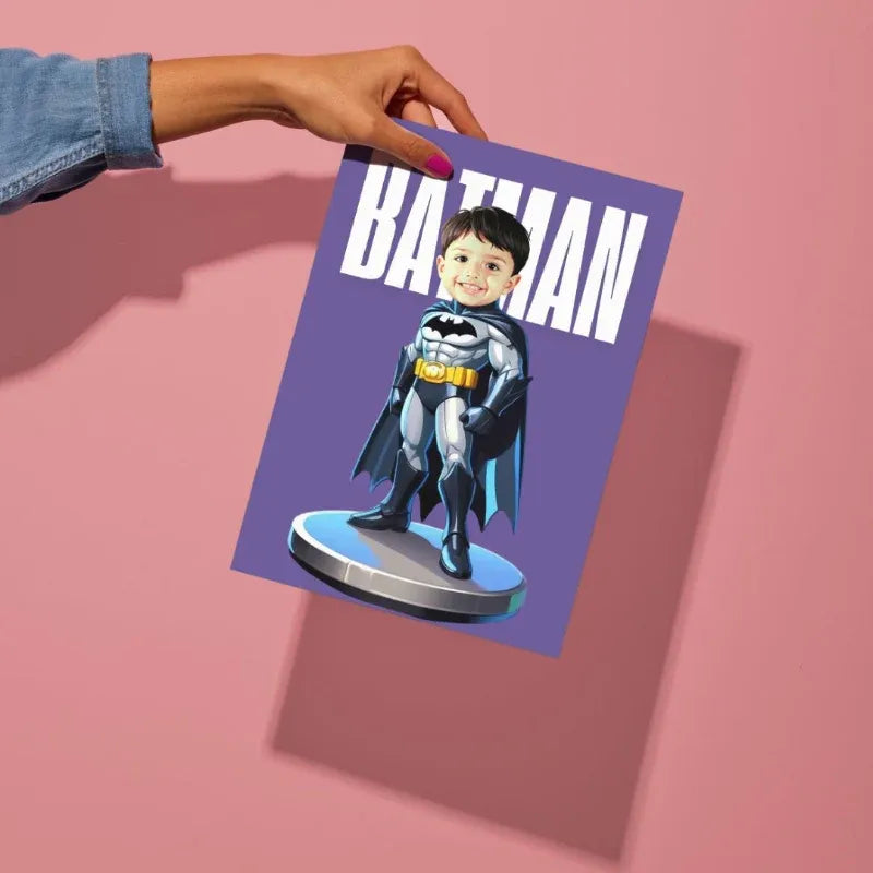 Hand holding a card with a child dressed as Batman on a pink background