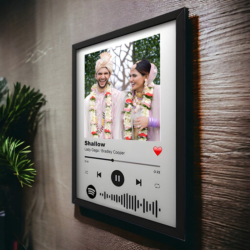 Framed picture of a couple with a music player interface on a wall.