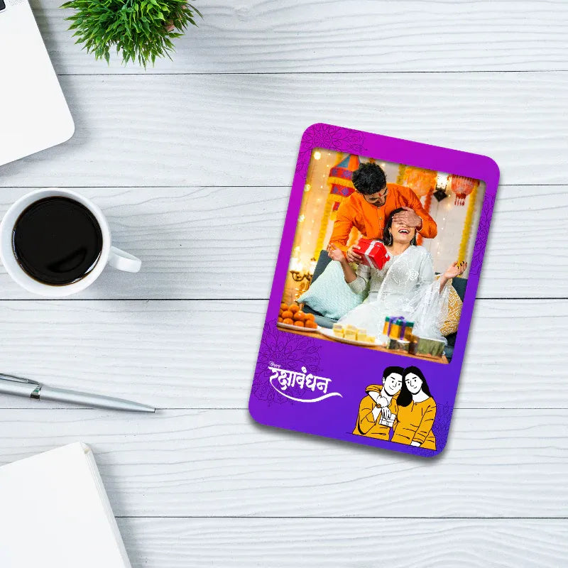 fridge photo magnet card with a printed photo of a sister and brother on a white wooden surface with a cup of coffee and pen.