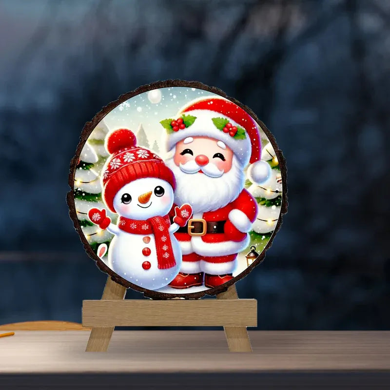 Decorative round sign with Santa Claus and snowman on a stand against a blurred outdoor background.