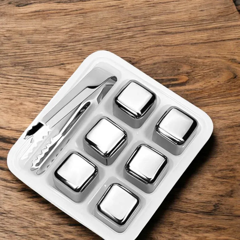 Set of stainless steel cubes with a tong on a wooden surface